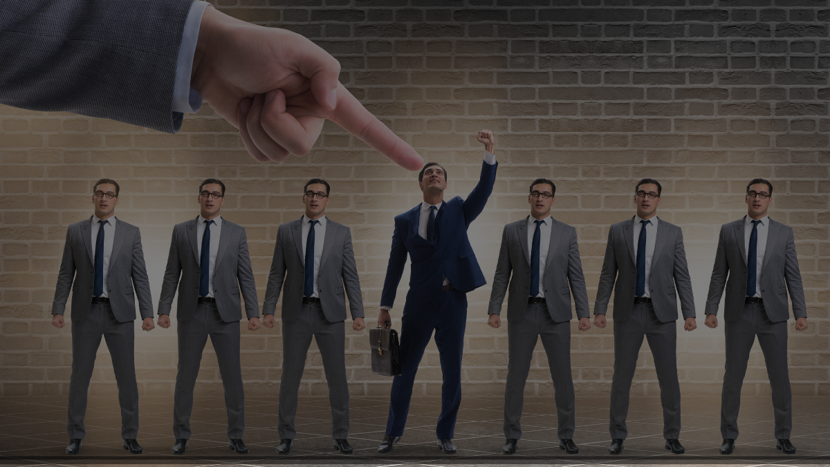 seven people standing in a row with a hand on top pointing to a person on center 